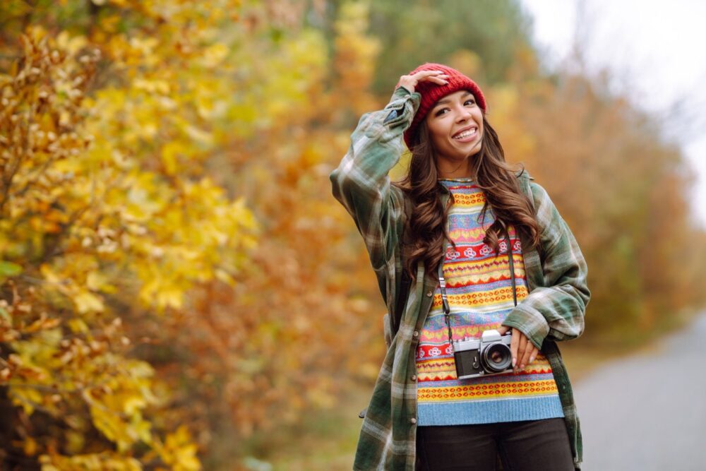 Kaunis nuori nainen kuvataan retrokameralla. Rentoutuminen, lepo, matkustaminen, elämäntyyli.